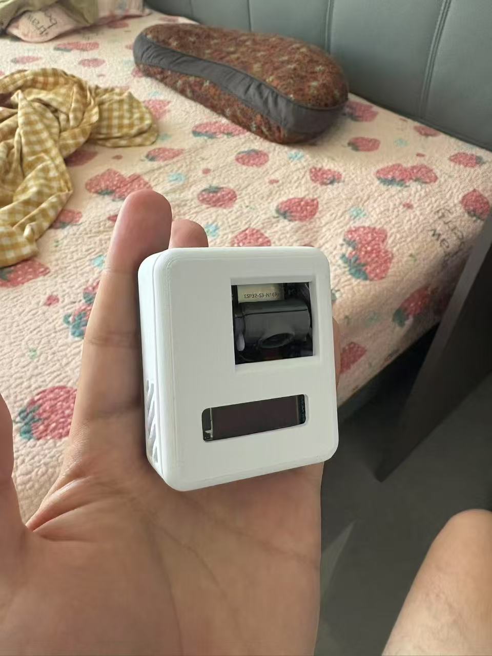 桌面终端特写：上方摄像头模组与下方 OLED 屏
